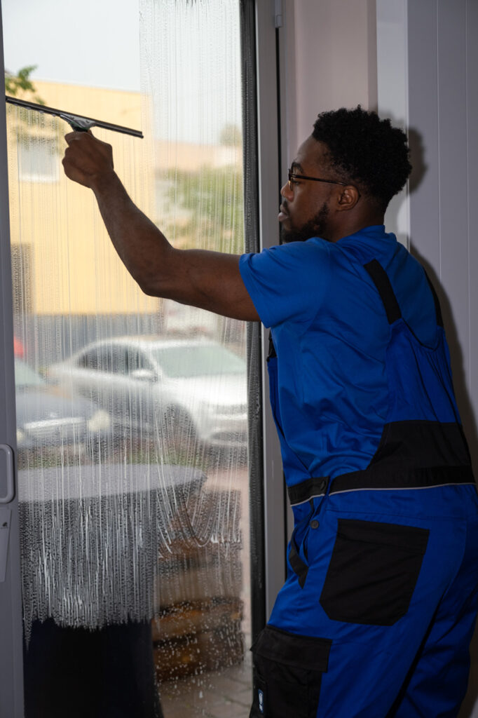Mitarbeiter reinigt Fenster